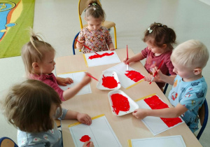 Dzieci malują farbami flagi