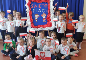 Dzieci z grupy Wiewiórki prezentują wykonane kotyliony oraz flagi