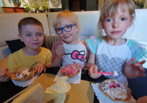 Dzieci degustują własnoręcznie udekorowane desery lodowe.