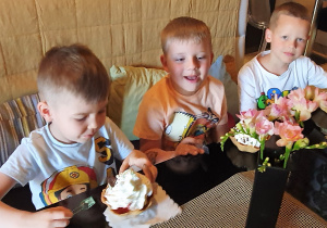 Chłopcy jedzą własnoręcznie wykonane desery lodowe.