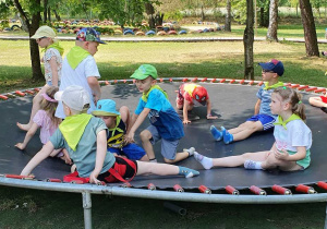 Dzieci skaczą na trampolinie.