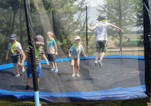 Dzieci skaczą na trampolinie.