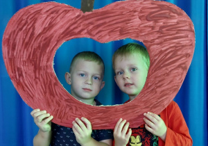 chłopcy pozują do zdjęcia w jabłkowej fotobudce