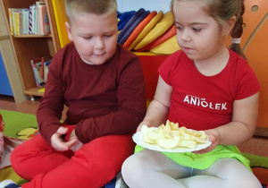 Dziewczynka z chłopcem degustują jabłka