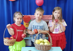 Dzieci robią pamiątkowe zdjęcie przy straganie z jabłkami