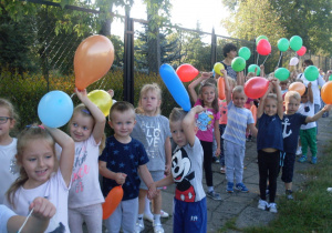Spacer dzieci z kolorowymi balonikami.