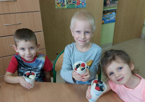 Dzieci prezentują przygotowaną przez siebie sałatkę owocową