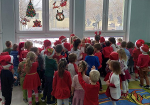 Dzieci witają Mikołaja, który pojawił się za oknem