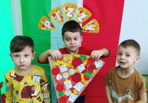Dzieci prezentują swój kawałek pizzy