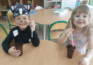 Dzieci piją mleczko przez słomki