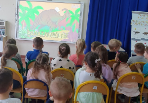 Dzieci oglądają prezentację multimedialną o dinozaurach