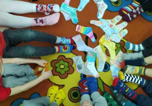 Dzieci prezentują kolorowe skarpetki nie do pary
