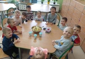 Dzieci spożywają sałatkę owocową