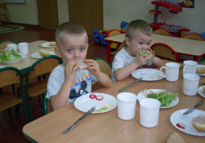 Dzieci jedzą kanapki.