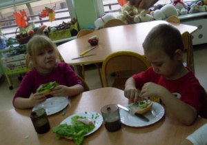 Dzieci jedzą kanapki.