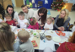 Dzieci z rodzicami dekorują pierniczki