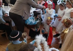 Dzieci przyjmują upominki wykonane przez seniorów.