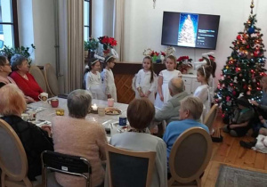 Dziewczynki w strojach aniołków recytują wiersz.