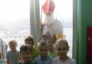 Świety Mikołaj zagląda przez okno do sali.