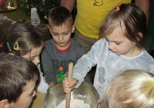 Dzieci mieszają składniki na ciasto.