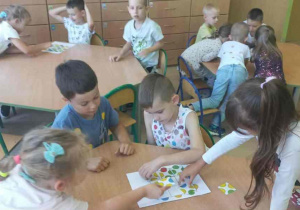 Dzieci pracują w grupach układając zakodowane kropki.