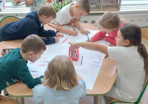Dzieci rysują współnie Miasto marzeń.
