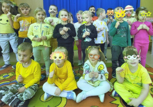 Dzieci wykonują pamiątkowe zdjęcie z użyciem śmiesznych rekwizytów.