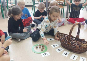 Przedszkolaki przeliczają dary natury.