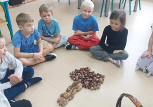 Żabki prezentują drzewko z darów natury.