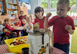 Dzieci przygotowują sok jabłkowy.