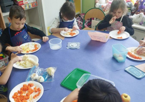 Dzieci kroją warzywa na sałatkę.