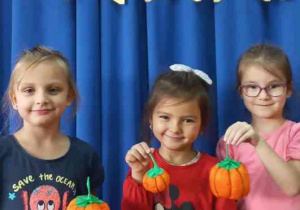 Dziewczynki prezentują dynie z bibuły.