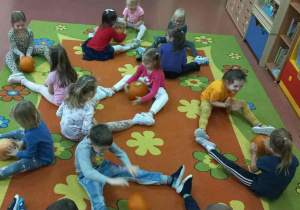 Dzieci turlają w parach dynie.