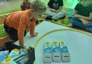 Chłopiec tworzy zbiór z wykorzystaniem plastikowych pojemników.