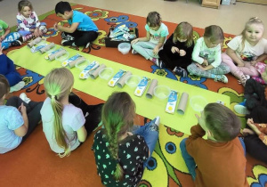 Dziewczynka układa rytm matematyczny z odpadów.