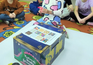 Dziewczynka za pomocą zmysłu dotyku określa co znajduje się w balonie.