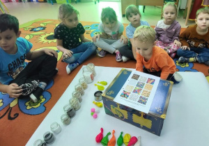 Chłopiec losuje balon z kuferka.