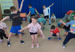 Dzieci robią przysiady,symulując lądowanie na Księżycu.