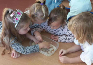 Dziewczynki oddzielają ziarna grochu od ryżu.