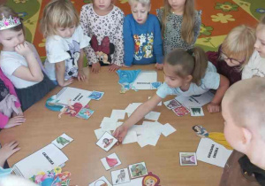 Dziewczynka dopasowuje ilustrację do tytułu książki.