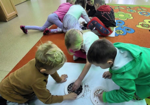 Dzieci oddzielają nasiona grochu od maku.