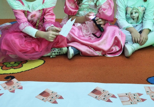 Dziewczynki z użyciem latarki zgadują,jaki bajkowy bohater ukrył się za drzwiami zamku.