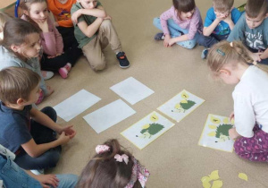 Dzieci układają odpowiednią liczbę liści na jeżach.