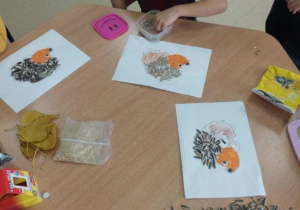 Dzieci przyklejają jeżom kolce ze słonecznika.