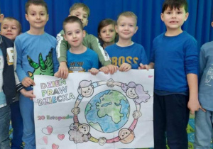 Żabki prezentują plakat Praw Dziecka.