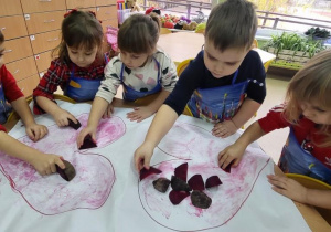 Dzieci malują serca burakiem.