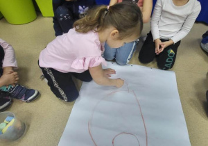 Dziewczynka rysuje misia.