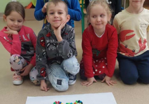 Żabki prezentują misia ułożonego z klocków.