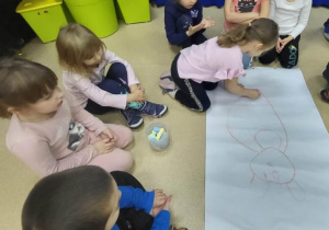 Dziewczynka rysuje misia do wierszyka.