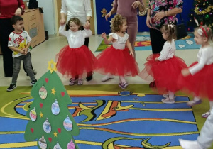 Dzieci tańczą wraz z rodzicami.